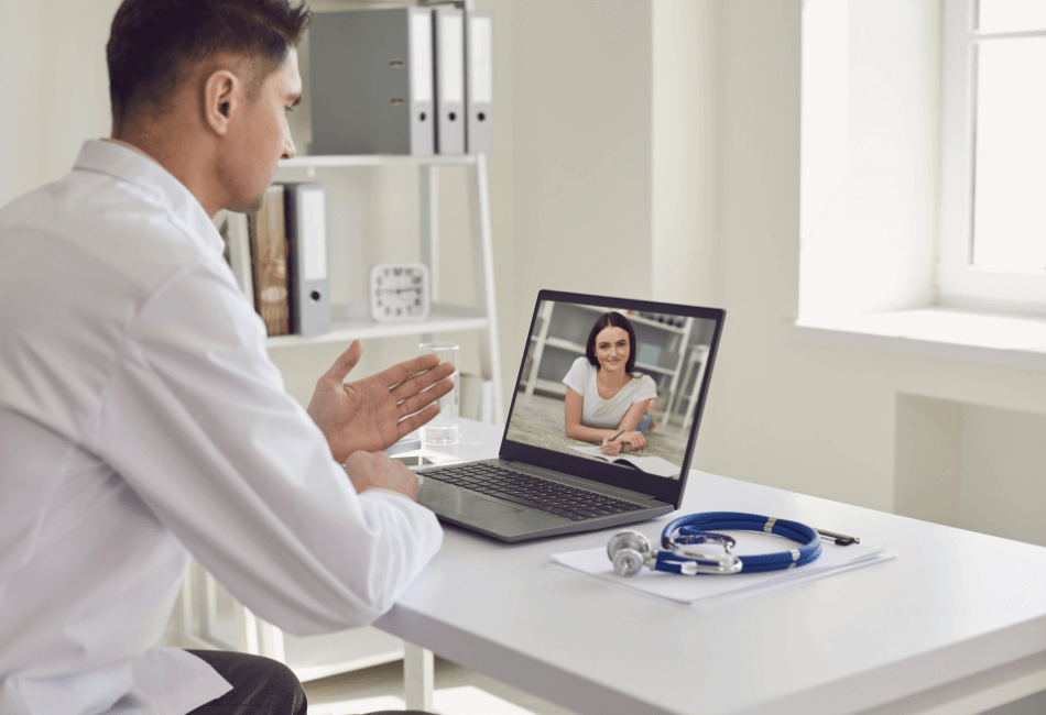 A doctor taking working at virtual clinic talking to a patient on the laptop